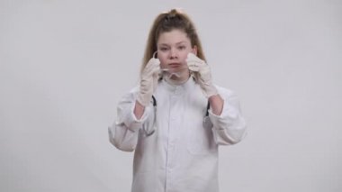 Çekici, kendine güvenen bir doktorun, şeffaf gözlük takıp kameraya gülümseyen bir portresi. Beyaz arka planda poz veren esmer, güzel beyaz bir kız. Tıbbi iş seçimi.