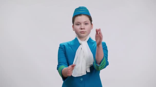 Caucasian girl in air hostess uniform crossing hands no gesture shaking head looking at camera with serious facial expression. Portrait of kid choosing aviation profession posing at white background. — Stock Video