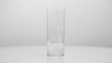 Masanın üzerine dökülen bardaklar tanınmaz hale geliyor. Yavaş çekimde sıvı dökülüyor..