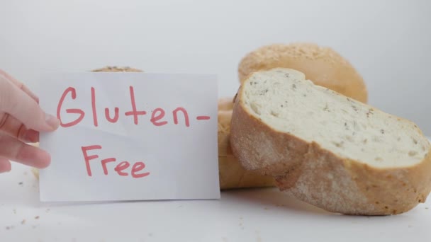 Närbild välsmakande bakverk skära bröd med kvinnlig hand sätta Gluten-fri meddelande i slow motion. Oigenkännlig säker kock visar läckra bakade bovete produkt. Reklam och vegetarianism. — Stockvideo