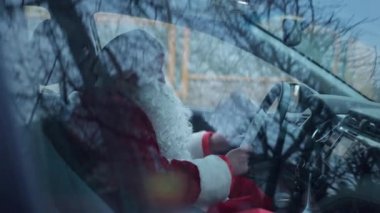 Arabanın camından Noel Baba 'yı vurmak, arabada oturup harflerle düşünmek. Kırmızı Noel Baba kostümü giymiş beyaz bir adam çocuklara hediye getiren adresleri arıyor..