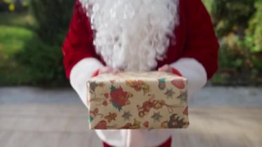 POV Noel Baba, arka verandada duran tanınmayan kişiye hediye veriyor. Kırmızı kostümlü, beyaz sakallı, öndeki adam yeni yılı kutluyor. Kişisel bakış açısı, canlı kamera..