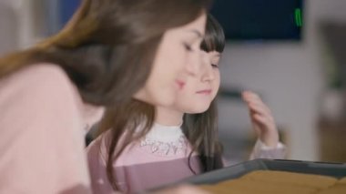 Çekici esmer beyaz kız enfes zencefilli kurabiye kokusu alıyor ve evde bir kadınla sarılıyor. Mutlu bir kızın portresi, annesinin evde lezzetli bir Noel tatlısı pişirmesine yardım ediyor..