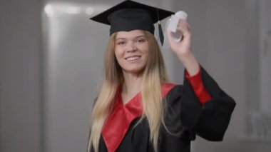 Zeki, kendine güvenen, gülümseyen, diplomalı bir kadın. Zeki, güzel, beyaz tenli, gülümseyen, böbürlenen diplomaya bakan birinin portresi. Yaşam tarzı ve eğitim.