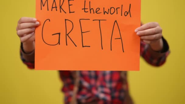 Närbild Få världen Greta att ringa in kvinnliga tonårshänder med gul bakgrund. Oigenkännlig ungdomlig miljöaktivist poserande med plakat. Miljöskador och miljöskydd. — Stockvideo