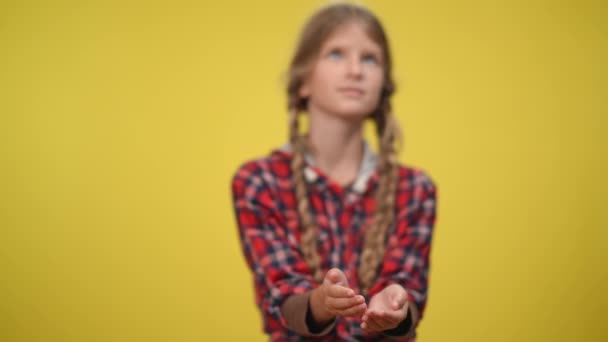 Water pouring in slow motion on hands of blurred teenage Caucasian girl at yellow background. Concept of environment and protection and conservation of water resources. — 图库视频影像