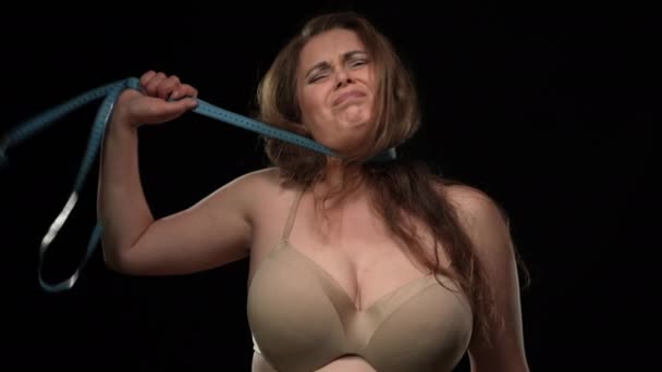 Medium shot overweight woman chocking with measuring tape at black background. Concept of social beauty standard and incompliance. Body positive. — Vídeo de Stock