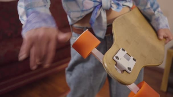 Close-up female hand spinning vintage skateboard wheel in slow motion indoors. Unrecognizable Caucasian woman with sports equipment standing at home enjoying leisure. 1980s skateboarding. — 비디오