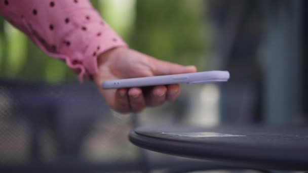 Närbild QR-kodsläsning med smartphone app på trottoarkafébordet på sommarterrassen. Oigenkännlig kaukasisk kvinna använder telefon kontrollera kaffe husmeny i slow motion. Service och bekvämlighet. — Stockvideo