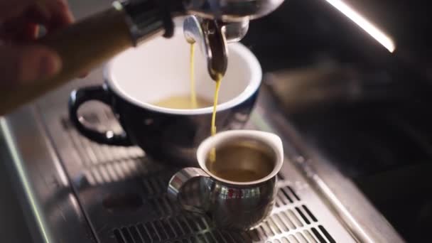Nagy látószögű barna kávé öntés lassított felvételű csésze espresso gép. Ízletes ízletes aromás ital elkészítése az étteremben kávézó beltérben. — Stock videók