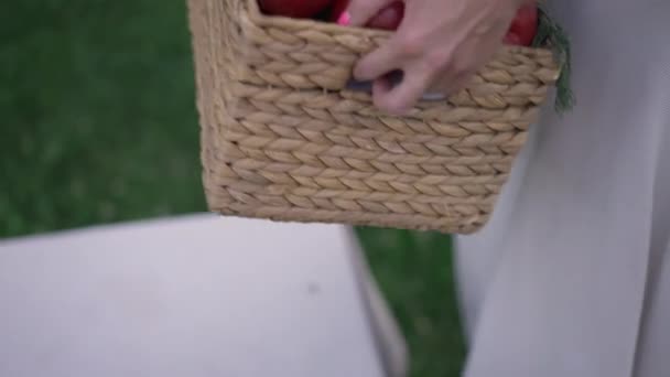 Close-up vrouwelijke handen zetten groentemandje op tafel buiten in slow motion. Onherkenbare jonge slanke blanke vrouw verzamelen oogst in de tuin op de zomer herfstdag. — Stockvideo