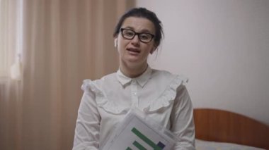 Görüntülü sohbette gülümseyen ve el sallayan güzel bir kadın. Kendine güvenen Kafkas uzmanının portresi. İnternette konferans veriyor. Evde çalışıyor ve evden ayrılıyor..