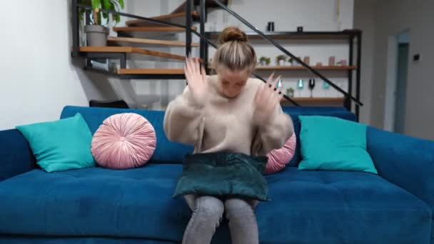 Naštvaná, vystresovaná puberťačka sedící doma na gauči v obýváku. Přední pohled portrét nervózní problémové kavkazské teenager kopání polštář s nespokojeným ustaraný obličeje — Stock video