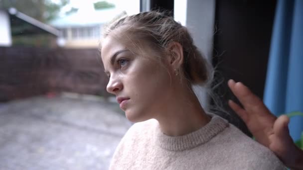 Adolescente deprimida mirando por la ventana como mano femenina tocando el hombro. Retrato de triste adolescente caucásico frustrado pensando en interiores en casa. Concepto de depresión y apoyo. — Vídeo de stock