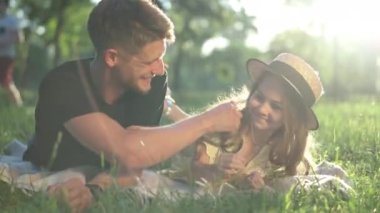 Neşeli adam, gülen kız, yaz mevsiminin çimlerinde, parkta yatıyor. Neşeli Kafkasyalı genç baba dışarıda güzel kızıyla eğleniyor. Bağ ve eğlence kavramı.