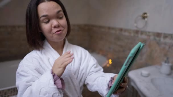 Mulher Sorrindo Conversando Tablet Tocando Pele Facial Banheiro Casa Retrato — Vídeo de Stock