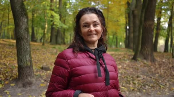Sonbahar Parkında Kameraya Bakan Kendine Güvenen Olgun Kadının Gülümsemesine Yakınlaş — Stok video