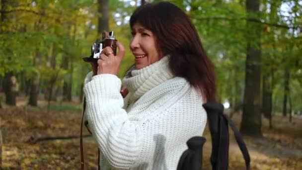 Вид Сбоку Талантливая Зрелая Женщина Фотографирует Камерой Стоящей Осеннем Лесу — стоковое видео