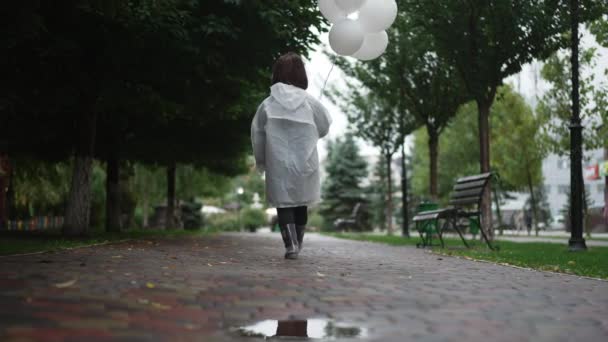 Amplia Vista Trasera Joven Mujer Abrigo Lluvia Con Globos Blancos — Vídeo de stock
