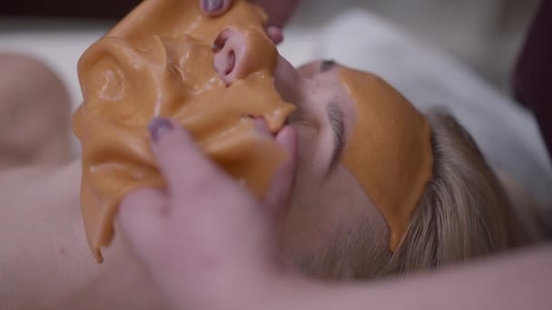 Kosmetikerin Zieht Gelbe Gesichtsmaske Aus Dem Gesicht Zufriedener Klientin Beauty — Stockvideo