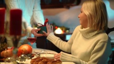 Ungrateful woman rejecting gift box looking at camera with annoyed facial expression. Portrait of thankless wife denying present of unrecognizable husband on Valentines Day posing