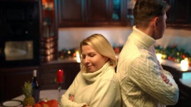 Argued dissatisfied Caucasian couple standing back to back looking at each other with irritated facial expression. Side view portrait of sad displeased husband and wife with crossed hands thinking