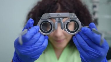 Bulanık doktorun hasta portresi yakın plan lens takıyor. Oftalmoloji kliniğinde görme cihazı olan beyaz profesyonel bir kadın. Optometri ve göz bilimi kavramı