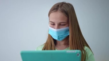 Üniformalı ve yüz maskeli zeki genç bir kadının yakın plan portresi laboratuardaki tablette çevrimiçi veritabanına bakıyor. Zeki beyaz kadın bilim adamı laboratuvarda sonuçları analiz ediyor.