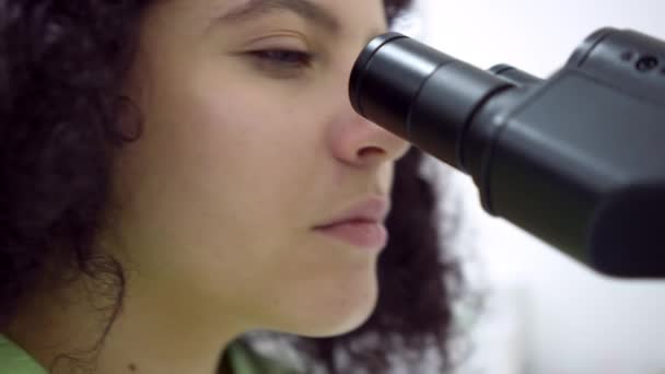 Zbliżenie Twarz Skoncentrowanego Naukowca Używającego Mikroskopu Laboratorium Pomieszczeniach Młoda Skupiona — Wideo stockowe