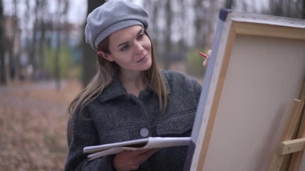 Joyful Talented Woman Painting Canvas Putting Brush Mouth Grimacing Looking — Vídeo de stock