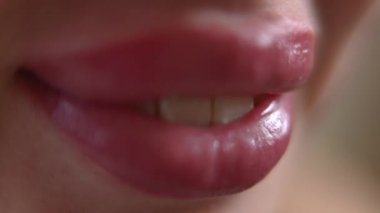Extreme close-up toothy smile of young confident woman with permanent lips makeup. Unrecognizable Caucasian positive lady smiling in slow motion. Femininity and self-care concept