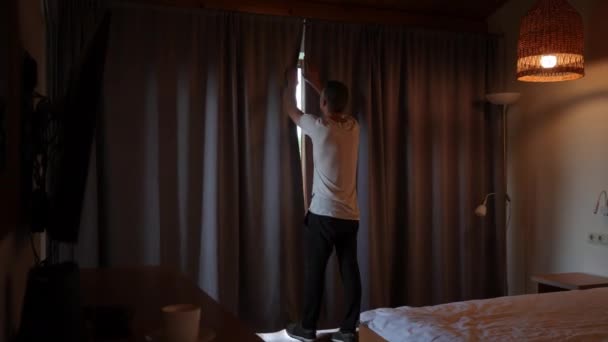 Wide Shot Back View Caucasian Young Man Opening Curtains Hotel — Vídeos de Stock