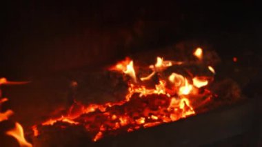 Firewood and coal burning in fireplace close-up. Red and yellow flame background