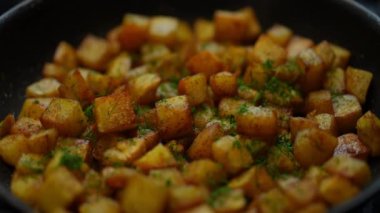 Potato frying with dill in cooking pan in kitchen close-up. Tasty delicious dinner preparation at home