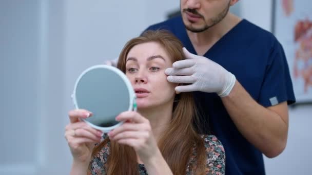 Caucasian Woman Looking Hand Mirror Middle Eastern Man Explaining Facelift — Stok Video