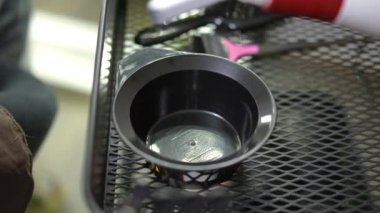 Close-up pouring hair mousse in round bowl in hair salon indoors. Unrecognizable hairstylist preparing vitamin treatment for client in beauty parlor. Slow motion