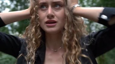 Yıkılmış endişeli kadın el ele tutuşup yaz parkında panik atak geçiriyor. Dışarıdaki korkmuş beyaz kadın stresli bir şekilde hareket ediyor. Yavaş deklanşör hızı etkisi