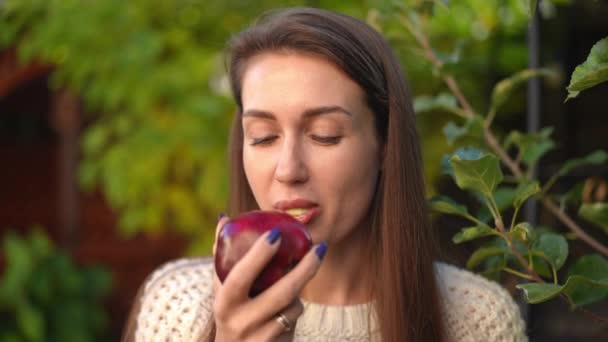 Λεπτή Γυναίκα Απολαμβάνοντας Γεύση Από Νόστιμο Κόκκινο Μήλο Μάσημα Κοιτάζοντας — Αρχείο Βίντεο