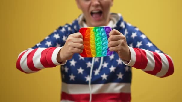 Mujer Joven Estirando Colorido Juguete Silicona Gritando Fondo Amarillo Irreconocible — Vídeos de Stock