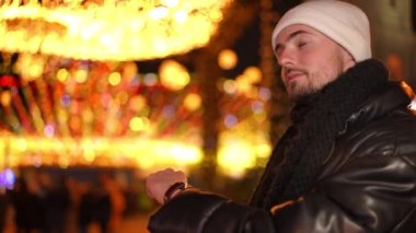 Kenar manzaralı, yakışıklı, beyaz bir adam, şehir merkezinde Noel gecesi dışarıda nöbet tutuyor. Yeni yıl arifesini bekleyen endişeli adam dışarıda, sağda duruyor.
