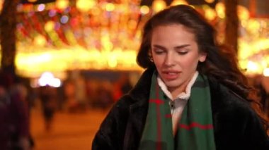 Dışarıda erkek bekleyen güzel genç bir kadının portresi sevgilisine Noel hediyesi veren elleri ile gözlerini kapatan bir erkek arkadaş gibi. Mutlu Kafkasyalı çiftler yeni yıl gecesi şehir merkezinde buluşuyor.