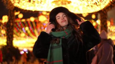 Canlı kamera, yeni yıl arifesinde şehir sokağında yavaş çekimde dans eden neşeli, kaygısız genç kadına odaklan. Mutlu, rahat, Kafkasyalı bayan gülümseyerek dışarıda Noel 'in tadını çıkarıyor.