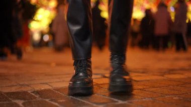 Deri pantolonlu, çizmeli, ince bacaklı genç bir kadın gece kaldırımında ağır çekimde dans ediyor. Tanımlanamayan milenyum hanımı Noel 'i dışarıda eğlenerek geçiriyor.