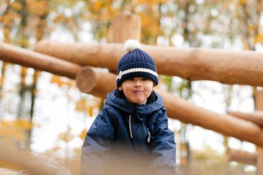 Çocuk parkında kameraya dilini gösteren şirin bir çocuk.