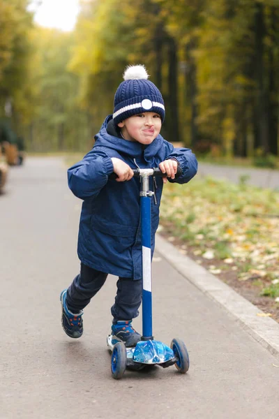 Scooter 'la scate Park' ta şık bir kıyafetle gezen sevimli, komik çocuk.