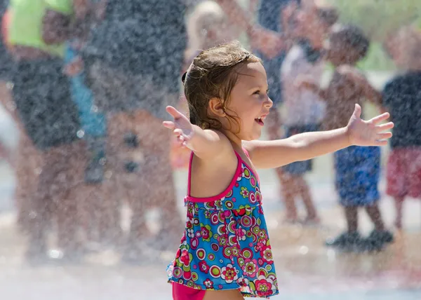 Happy little girl in a summer fountain — Stock Photo, Image