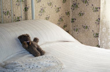 Vintage oyuncak ayı beyaz bir yatakta