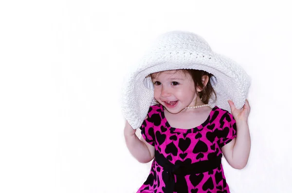 Criança com um grande chapéu branco e pérolas — Fotografia de Stock