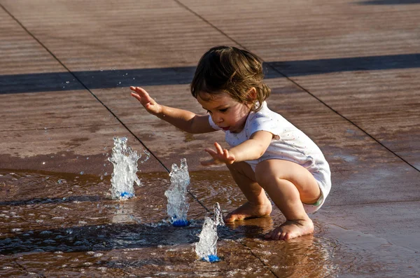 Щасливий малюк у міському фонтані — стокове фото