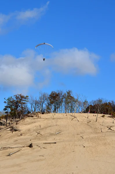En hängglidare flyger in sand dynerna på warren dunes state park — Stockfoto